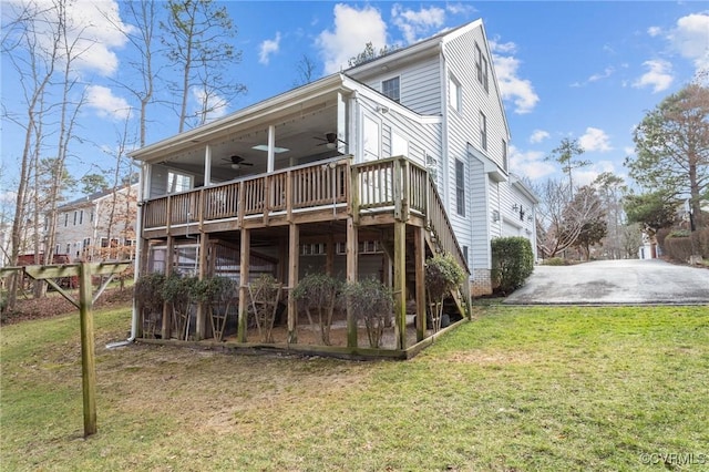 rear view of house with a ceiling fan, a lawn, stairway, and a deck