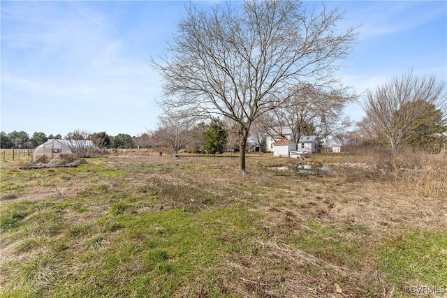 view of yard with an outbuilding, a rural view, and an exterior structure