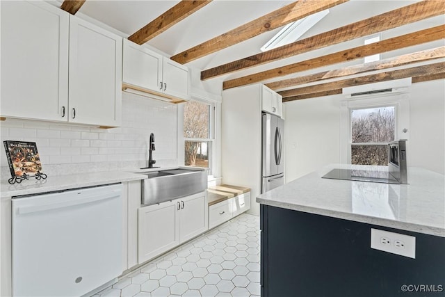 kitchen featuring dishwasher, a sink, and white cabinets