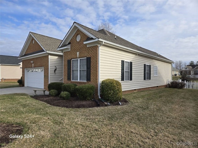 view of side of home with driveway, brick siding, and a lawn