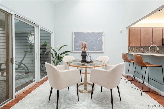 dining space featuring light wood finished floors and baseboards