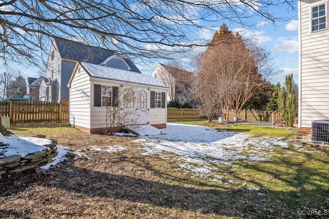 exterior space featuring a shingled roof, a yard, central AC, and fence