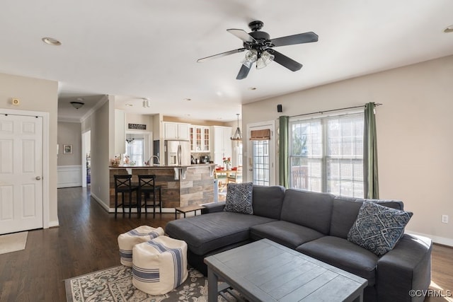 living area featuring dark wood-style flooring, ceiling fan, and baseboards