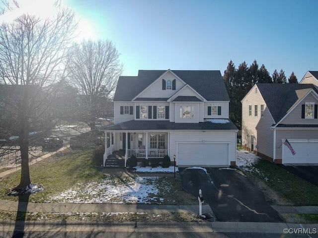 view of front of home featuring driveway, a porch, and an attached garage