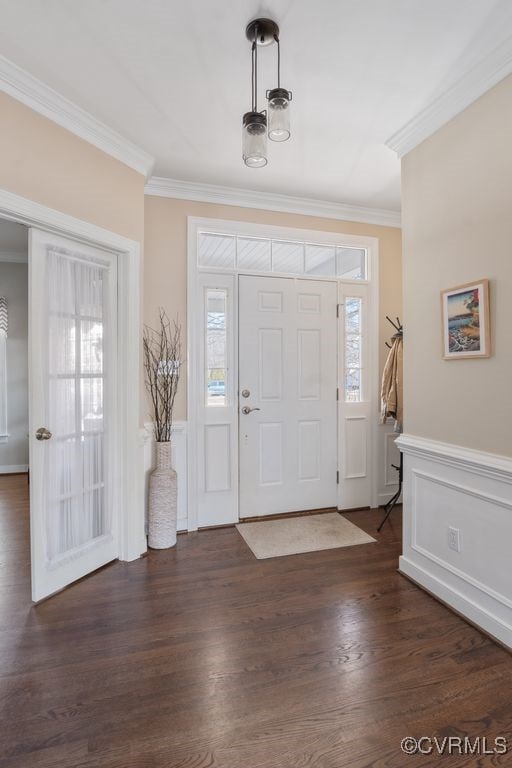 foyer entrance featuring plenty of natural light, crown molding, dark wood-type flooring, and wainscoting