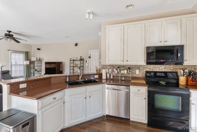 kitchen with black appliances, a peninsula, and white cabinets