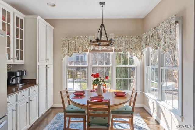 dining room with a chandelier, baseboards, and wood finished floors