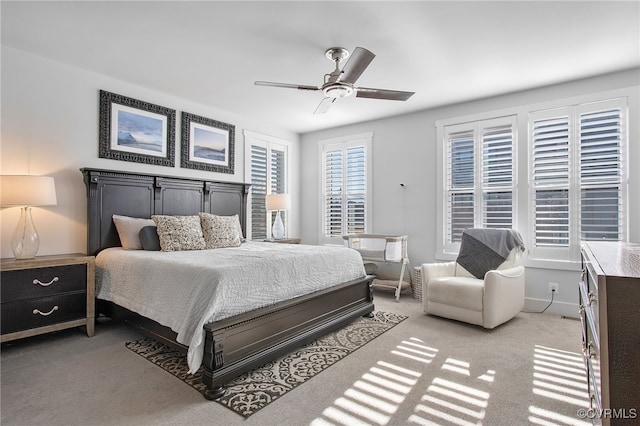 bedroom featuring light carpet, ceiling fan, and baseboards