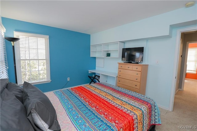 bedroom with light carpet and baseboards