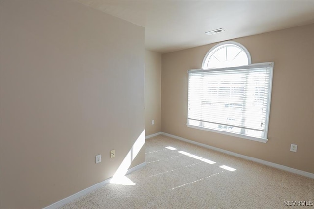 unfurnished room with light colored carpet, visible vents, and baseboards