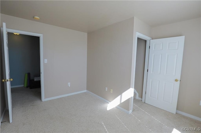 unfurnished bedroom featuring light carpet and baseboards