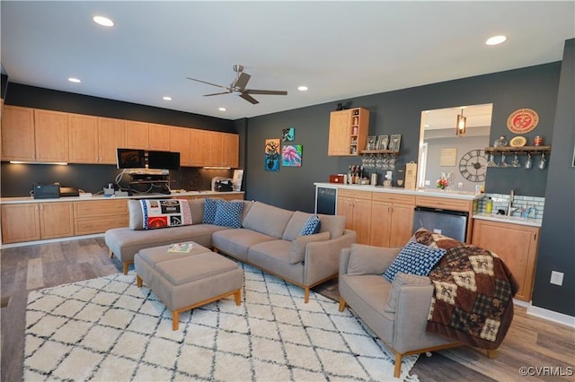 living room featuring light wood-type flooring, ceiling fan, bar area, and recessed lighting