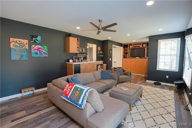 living area featuring recessed lighting, bar, light wood-style flooring, and baseboards