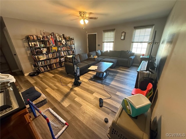 living area with ceiling fan, wood finished floors, and baseboards