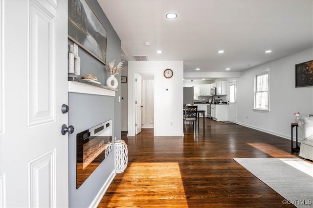 interior space featuring baseboards, dark wood finished floors, visible vents, and recessed lighting