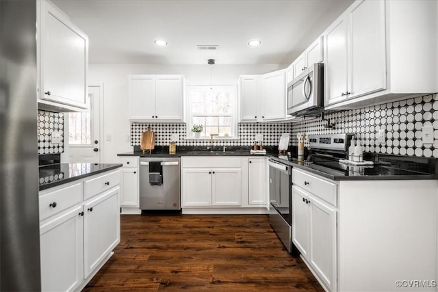 kitchen featuring white cabinets, a wealth of natural light, stainless steel appliances, and a sink