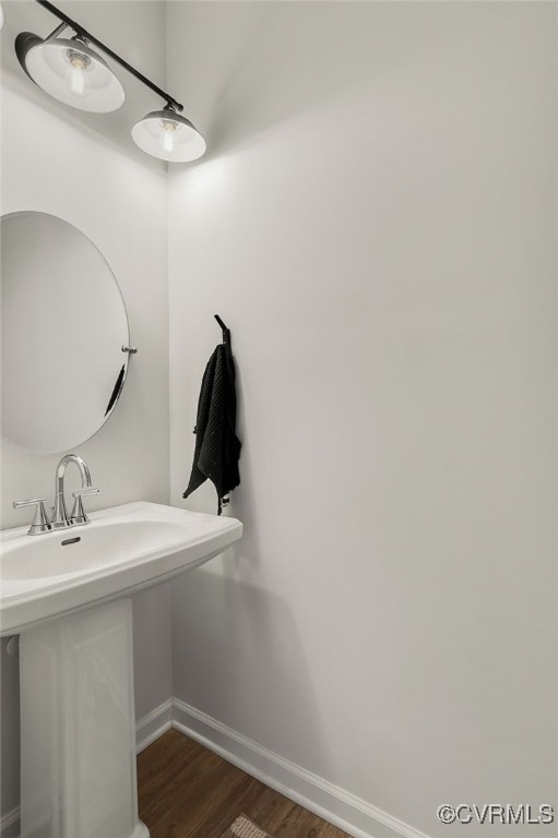 bathroom featuring a sink, baseboards, and wood finished floors