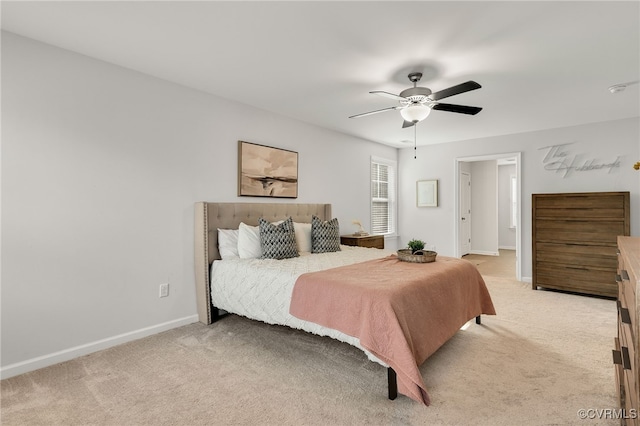 bedroom featuring a ceiling fan, light carpet, and baseboards