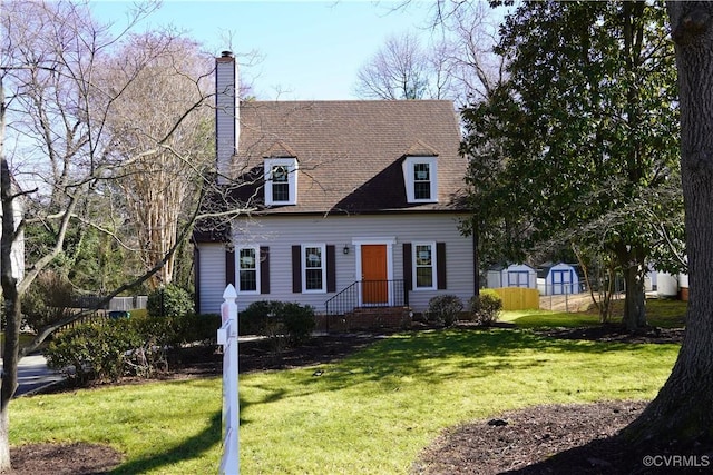 cape cod house with a front lawn, a chimney, and fence