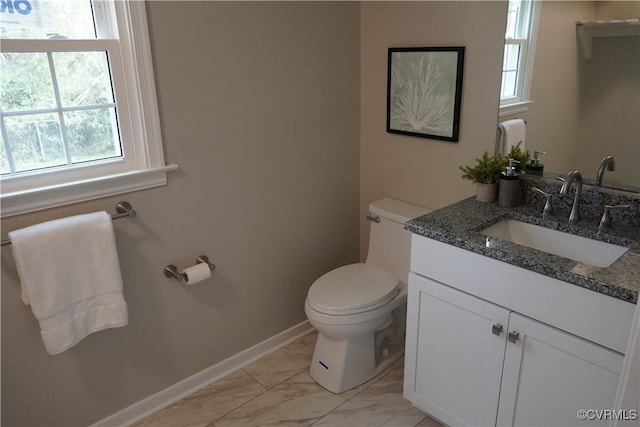 half bath with toilet, marble finish floor, baseboards, and vanity