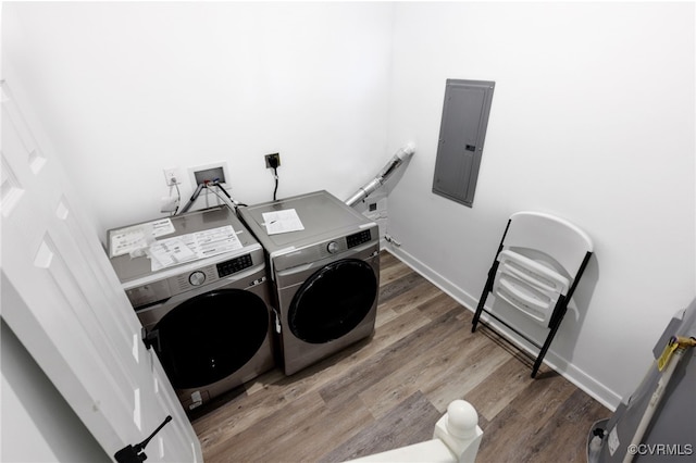 washroom featuring laundry area, separate washer and dryer, wood finished floors, baseboards, and electric panel