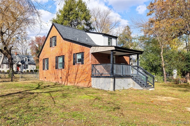 view of side of home with fence private yard, brick siding, a lawn, and stairs