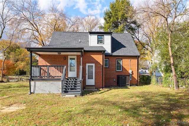 rear view of house featuring a yard, fence, and brick siding