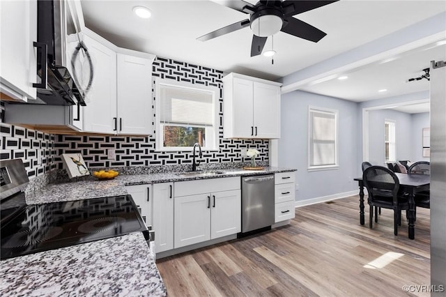 kitchen with stainless steel appliances, white cabinetry, and a sink