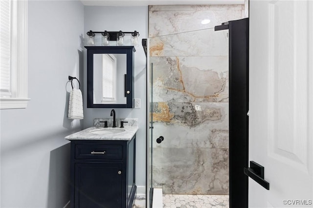 bathroom with a shower stall and vanity