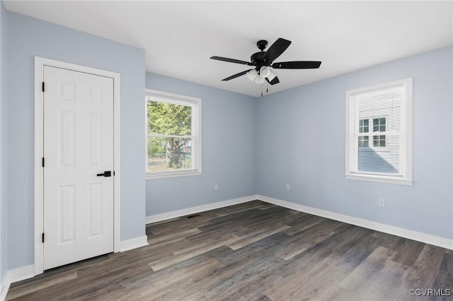 unfurnished bedroom featuring baseboards, dark wood finished floors, and a ceiling fan