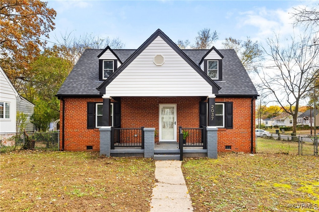 view of front of home with crawl space, brick siding, and fence