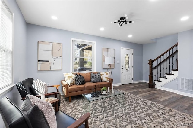 living area featuring recessed lighting, dark wood-style flooring, visible vents, and stairs