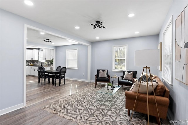 living room with baseboards, wood finished floors, and recessed lighting