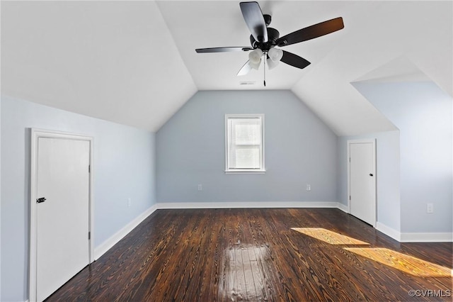 additional living space with dark wood-style flooring, visible vents, vaulted ceiling, ceiling fan, and baseboards