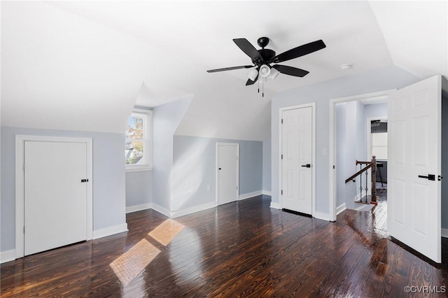 additional living space featuring lofted ceiling, dark wood-style floors, and baseboards