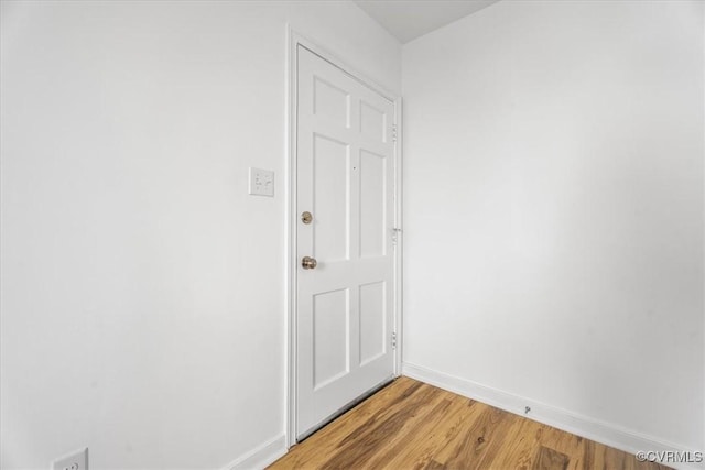 doorway with light wood-type flooring and baseboards