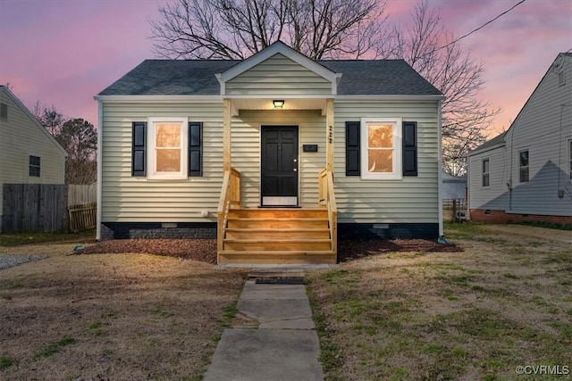 bungalow-style home with entry steps, crawl space, and fence