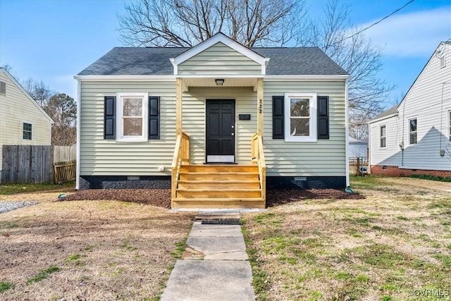 bungalow featuring entry steps, a shingled roof, crawl space, and fence