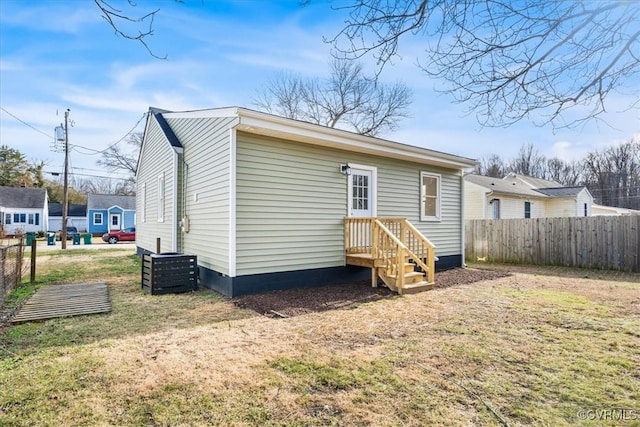 rear view of property with fence and a yard