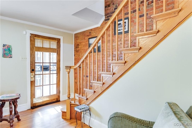 entryway with stairway, baseboards, crown molding, and wood finished floors