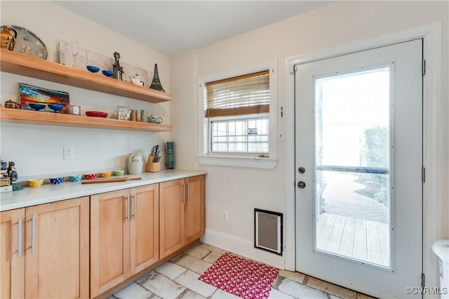 doorway to outside featuring baseboards