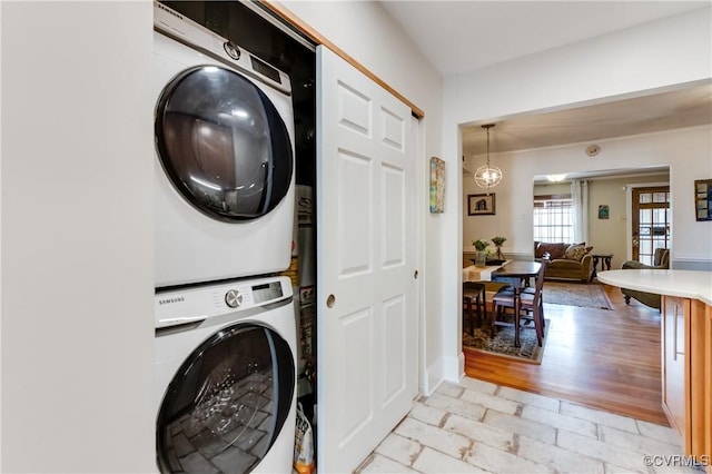 clothes washing area featuring stacked washer and dryer and laundry area