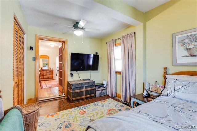 bedroom featuring arched walkways, ceiling fan, a closet, and tile patterned flooring