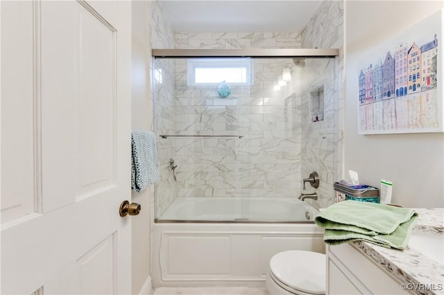 bathroom featuring enclosed tub / shower combo, vanity, and toilet