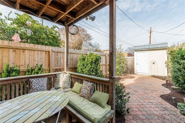 view of patio / terrace with a fenced backyard, a shed, and an outbuilding