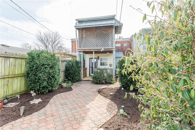 rear view of property featuring a patio and a fenced backyard