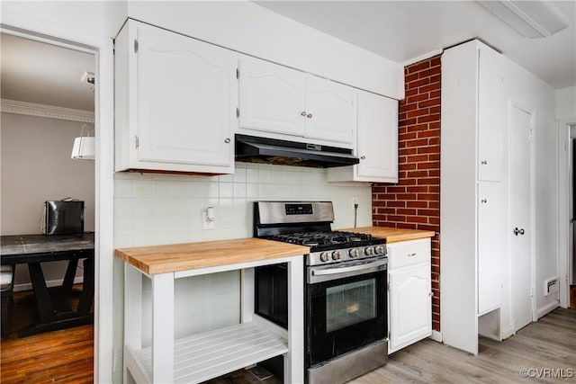 kitchen with under cabinet range hood, white cabinets, wooden counters, and gas stove