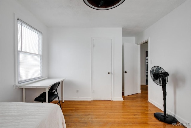 bedroom featuring baseboards and light wood finished floors