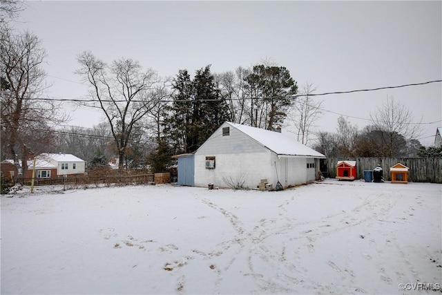 view of snow covered exterior with a garage and fence