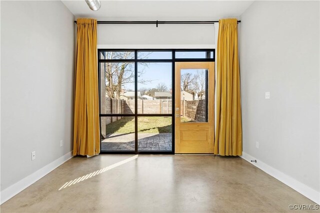 interior space featuring concrete floors and baseboards